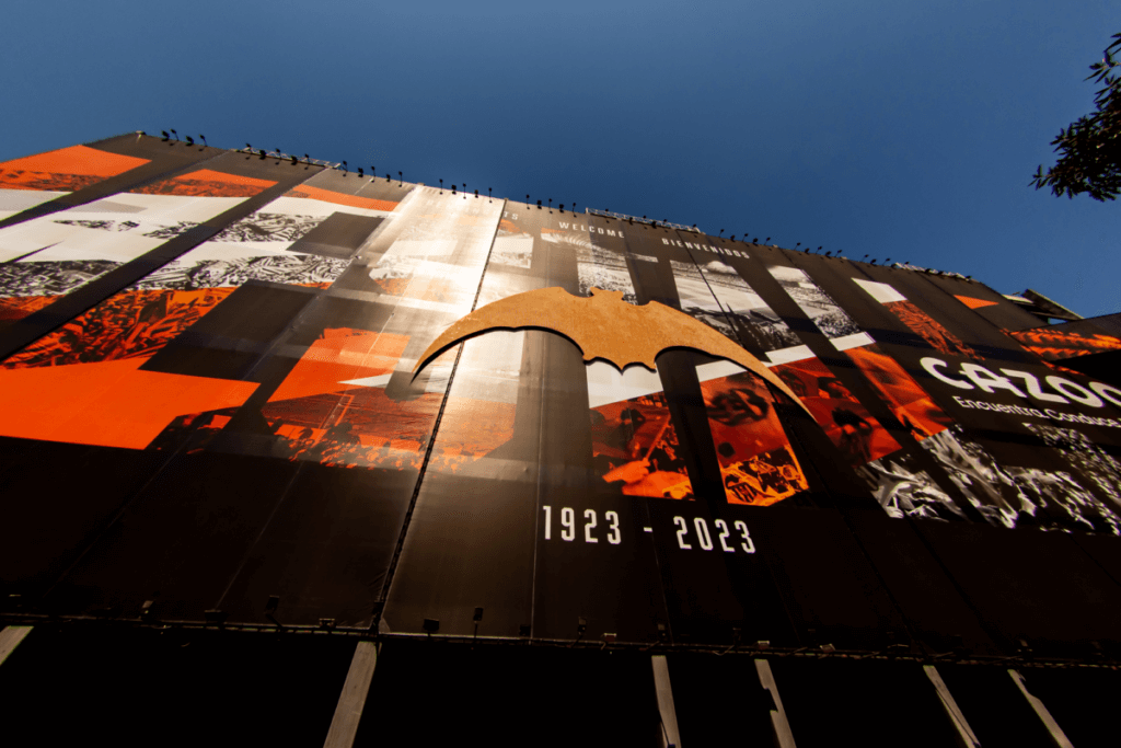Eine riesige Werbetafel an der Rückseite des Estadio Mestalla in Valencia. In den Farben orange, weiß und schwarz gehalten ist eine Fledermaus und die Jahreszahlen 1923 und 2023 zu erkennen.