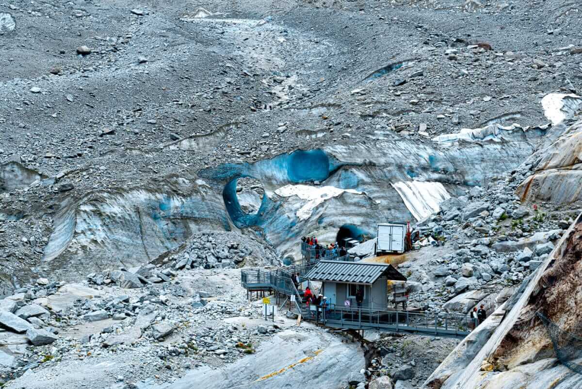 Mer de Glace ist ein Gletscher in den französischen Alpen. Hier sind man das untere Ende vom Gletscher. Eine Geröllwüste mit sichtbaren Öffnungen des Eises, welches unter den Steinen liegt.