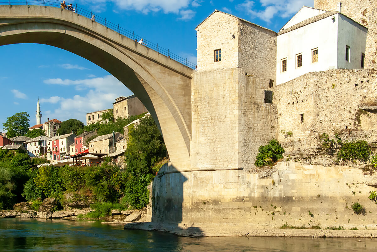 Die Alte Brücke in Mostar mit der darunter fliessenden Neretva. Der Blick vom Ufer nach oben zur Brücke.