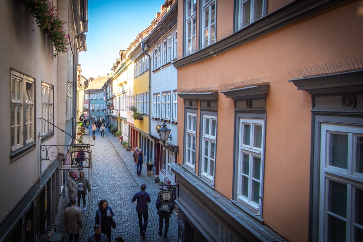 Die Krämerbrücke aus dem Fenster der St.Ägidien-Kirche aus betrachtet. Rechts und links der engen Straße stehen Häuser direkt nebeneinander.