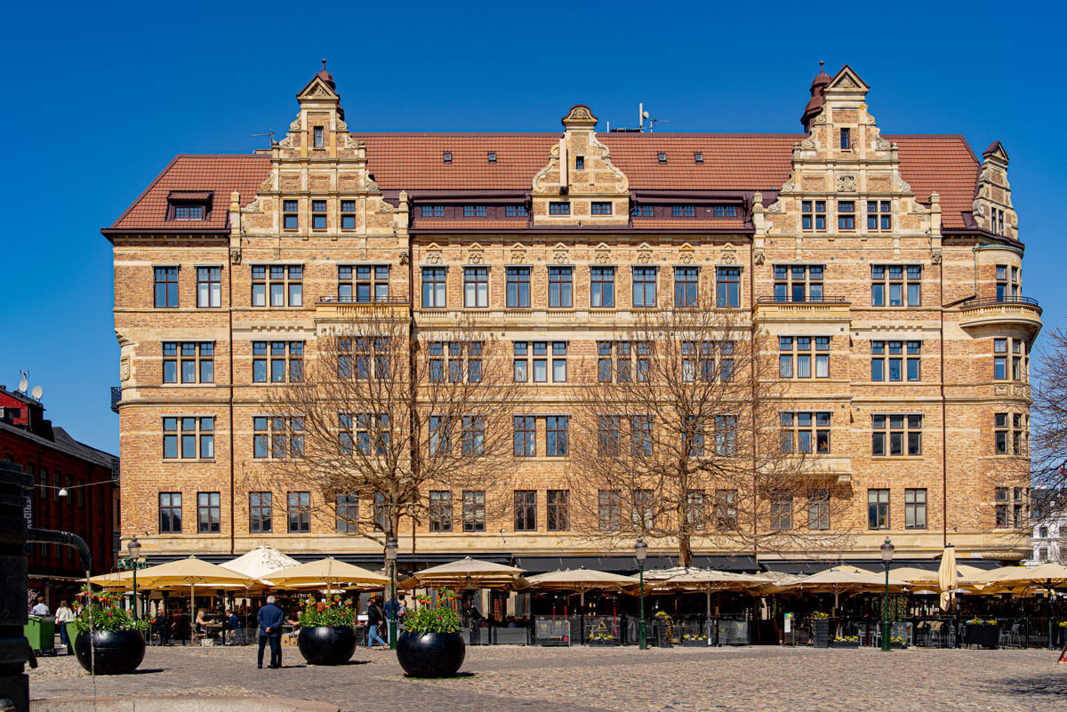 Ein historisches Backsteingebäude am Lilla Torg. Die Fassade ist reich verziert mit vielen Fenstern verteilt auf sechs Etagen.