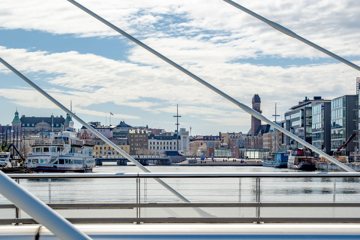 Von einer Brück blickt man über einen kleinen Hafen Richtung Altstadt von Malmö. Im Hintergrund kann man die Fassaden der Häuser gut erkennen.