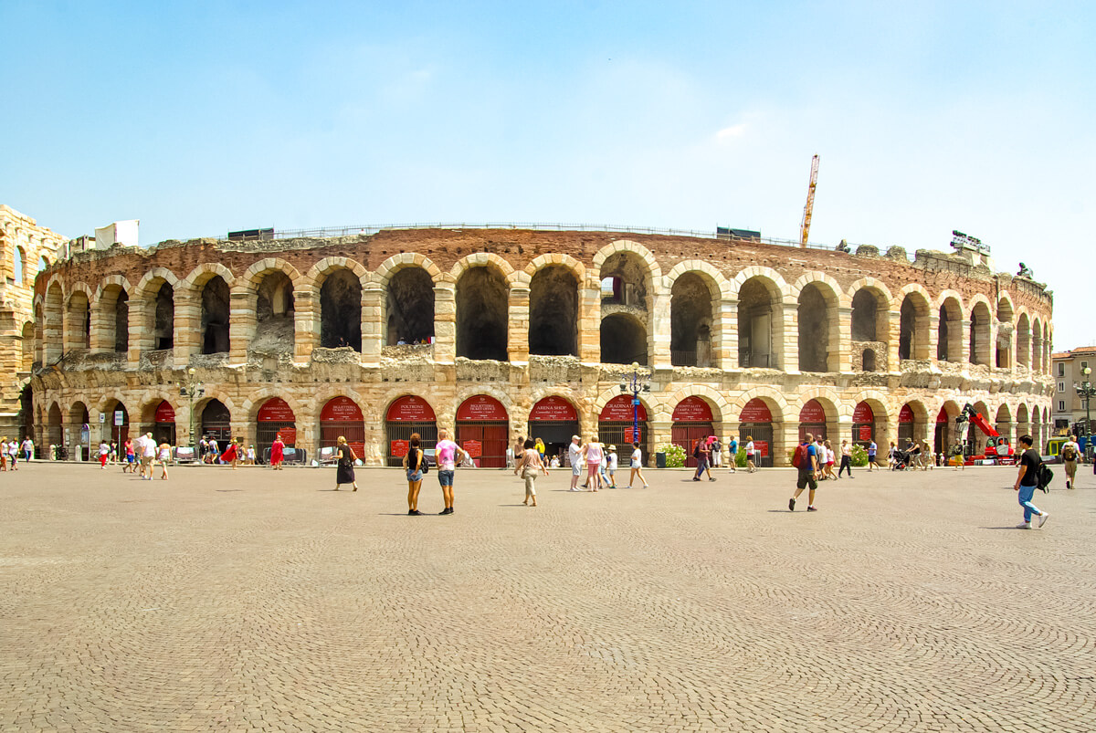 Kolosseum - Die Arena in Verona. Die Fassade der Arena besteht aus gemauerten Rundbögen. Vom großen Vorplatz aus kann man die gesamte Fassade des Kolosseum mit zwei Etagen von großen Rundbögen sehen. Der Platz davor ist mit Granitsteinen gepflastert.