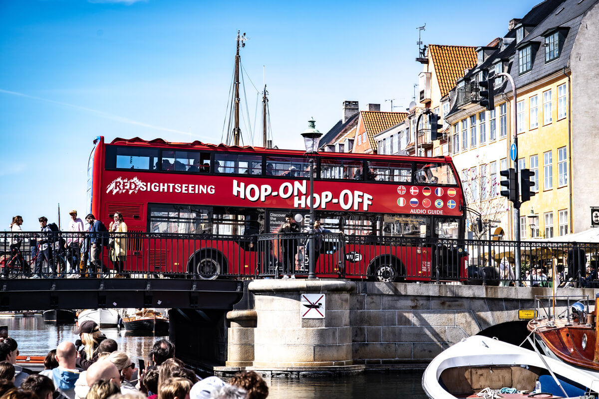 Die berühmten Hop On Hop Off Busse fahren am Hafen Nyhavn vorbei