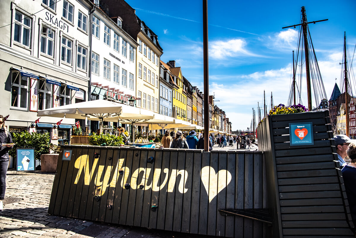 Schriftzug Nyhavn auf einem Holzgestell auf der Promenade des alten Hafens