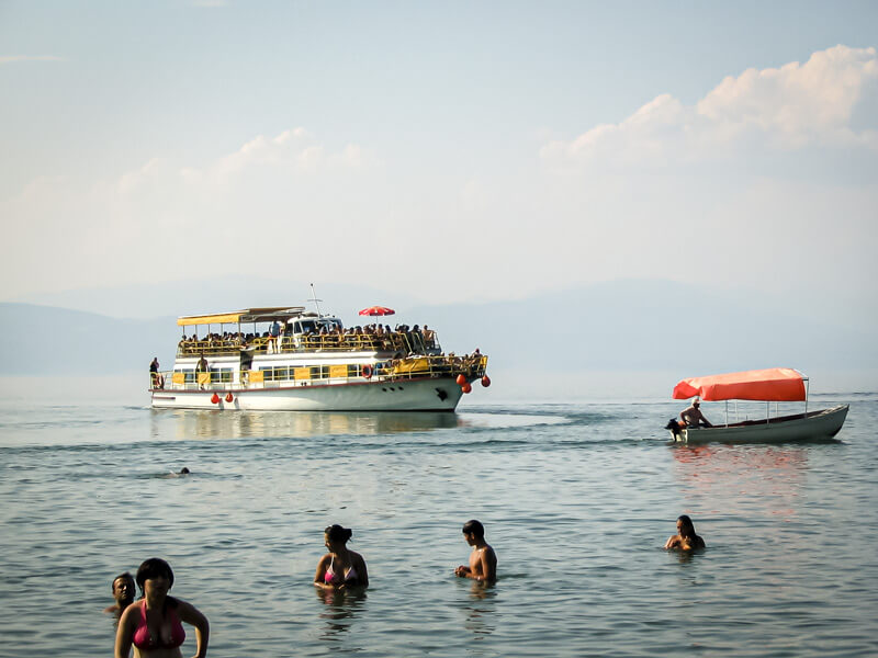 Ein Ausflugsboot fährt am Strand des Ohridsee.